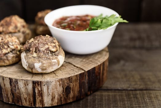 baked mushrooms with meat and sauce on a wood