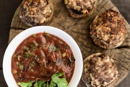 baked mushrooms with meat and sauce on a wood