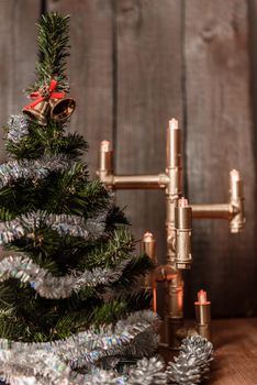 Christmas decorative tree is adorned with rain stands on the table with a lit lamp lights