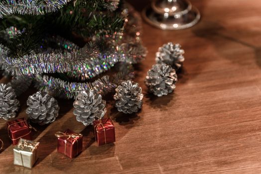 Christmas decorative tree is adorned with rain stands on the table with gifts and silver cones