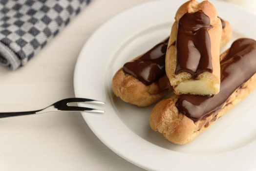 profiteroles with butter cream and chocolate topping on the plate