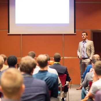 Speaker Giving a Talk at Business Meeting. Audience in the conference hall. Business and Entrepreneurship concept.