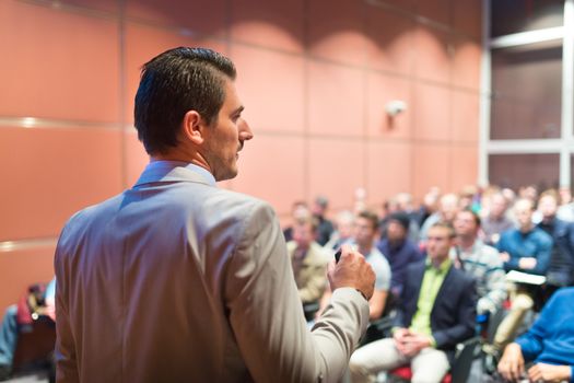 Speaker at Business Conference with Public Presentations. Audience at the conference hall. Business and Entrepreneurship concept. Background blur. Shallow depth of field.