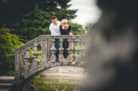 Young couple leaning on railing of bridge 