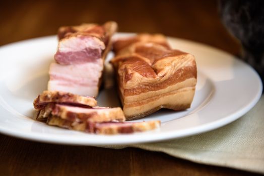 smoked pork ribs on white plate on wooden background