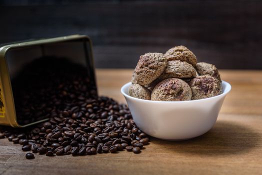 coffee cookies in a white plate with coffee beans on wooden brown table