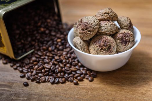 coffee cookies in a white plate with coffee beans on wooden brown table