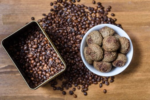 coffee cookies in a white plate with coffee beans on wooden brown table