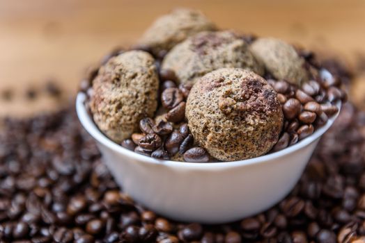 coffee cookies in a white plate with coffee beans on wooden brown table