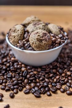 coffee cookies in a white plate with coffee beans on wooden brown table