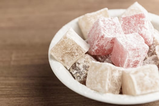 delight yellow and red on a plate sprinkled with powdered sugar