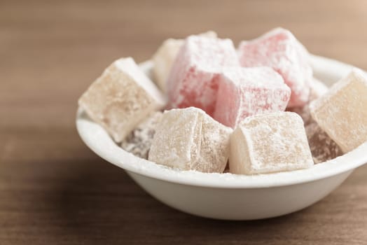 delight yellow and red on a plate sprinkled with powdered sugar