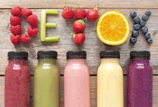 Assorted flavoured smoothie juices in bottles with detox spelt using fruits and vegetables