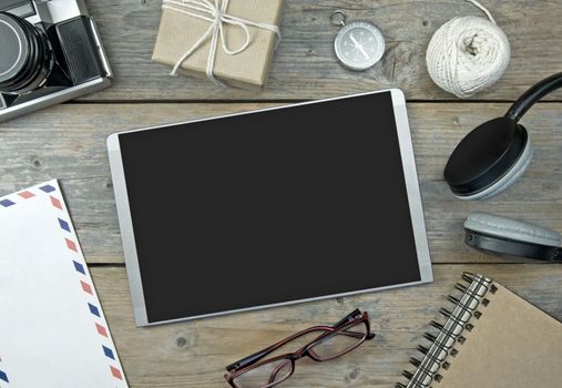 Blank digital tablet with stationery objects, compass and camera