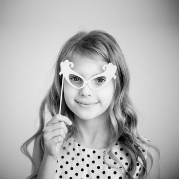 Black and white photography of a lovely little girl with funny party paper glasses or mask