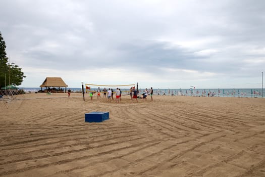 they plays volleyball on the beach near the sea on a sunny day