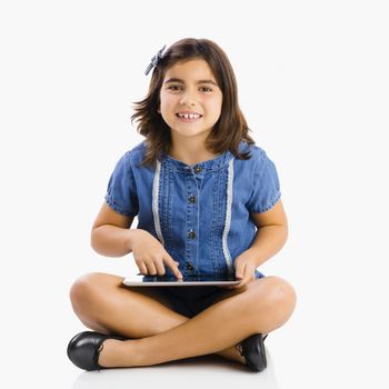 Young girl sitting on floor and using a tablet