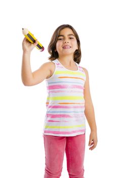 Beautiful young girl holding a big pencil and writing something on a glass wall