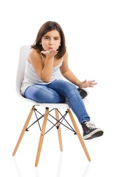 Studio portrait of a beautiful young girl sitting on a chair sending a kiss