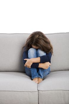 Little girl sitting on a couch and upset with something