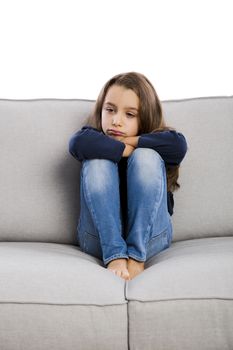 Little girl sitting on a couch and upset with something