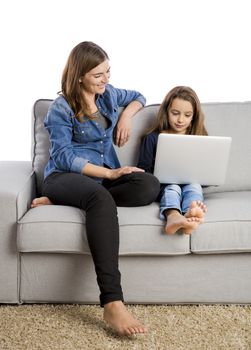 Mother teaching her little daughter working with a laptop