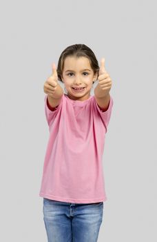 Studio portrait of a beautiful little girl with thumbs up