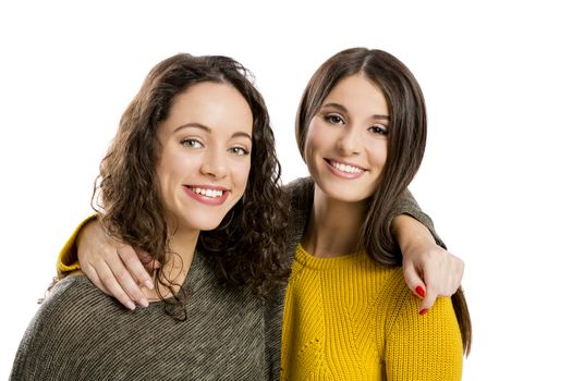 Studio portrait of two beautiful girls smiling