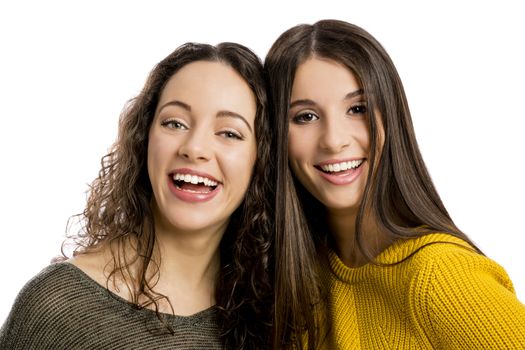 Studio portrait of two beautiful girls smiling