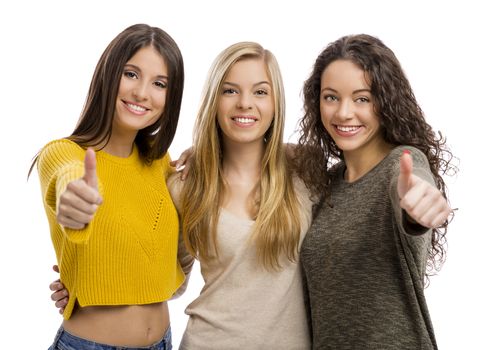 Studio portrait of three teenage girls with thumbs up