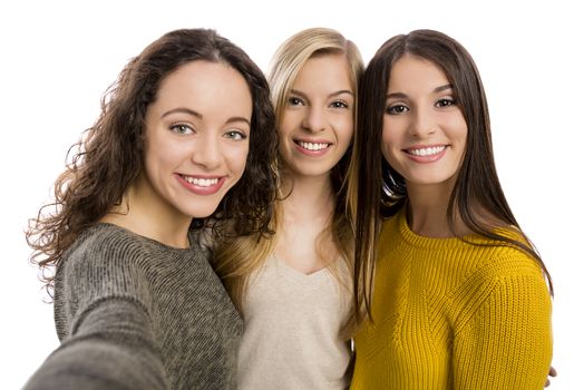 Studio portrait of three beautiful teenage girls smiling