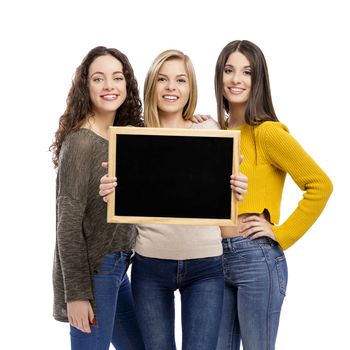 Studio portrait of three teenage girls holding a chalkboard