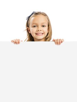 Beautiful little girl holding and showing something on a whiteboard