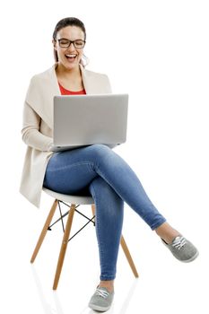 Beautiful and happy woman working with a laptop, isolated over white background 