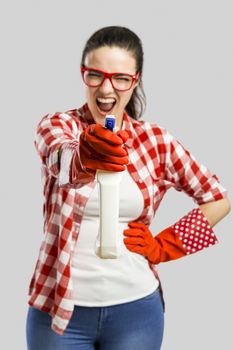 Pretty woman wearing gloves and holding a cleaning spray 