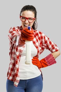 Pretty woman wearing gloves and holding a cleaning spray 