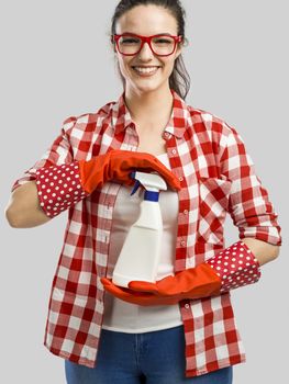 Pretty woman wearing gloves and holding a cleaning spray 