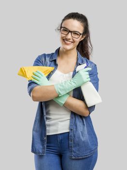 Pretty woman wearing gloves and holding a cleaning spray and a cloth