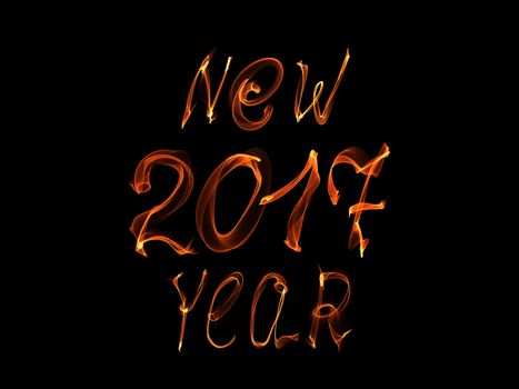 Happy new year 2017 isolated text and numbers written with flame light on black background.