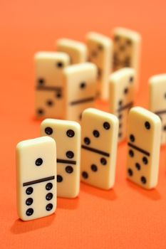 Black dominoes standing in a row on red background