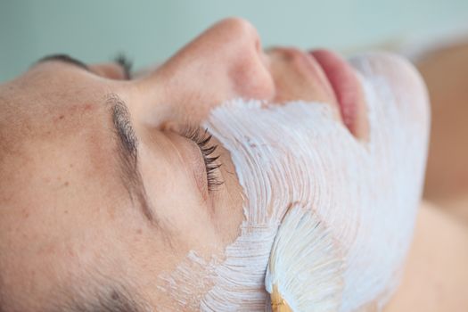 Woman receiving a facial mask treatment