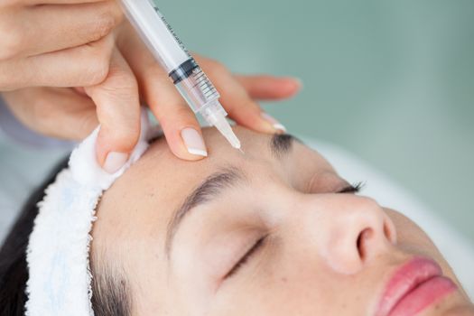 Doctor applying a facial treatment to a woman