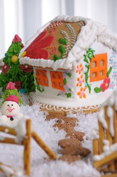 Gingerbread house painted in ethnic style among the trees and snow