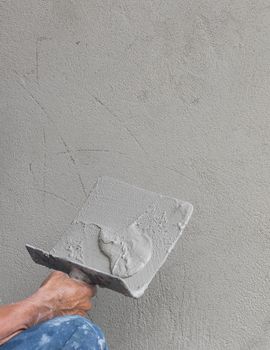 Builder worker plastering concrete  at wall of house construction