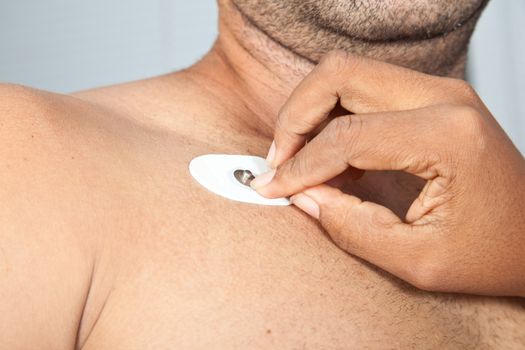 Nurse placing an electrode on patient's chest