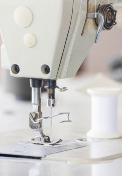 Close up industrial sewing machine in textile factory