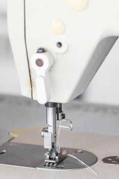 Close up industrial sewing machine in textile factory