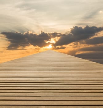 Wood walkway to sky at sunset under cloudy