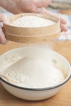 Women's hands preparing flour before baking pie.