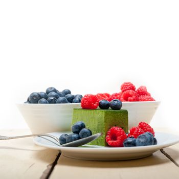 green tea matcha mousse cake with raspberries and blueberries on top